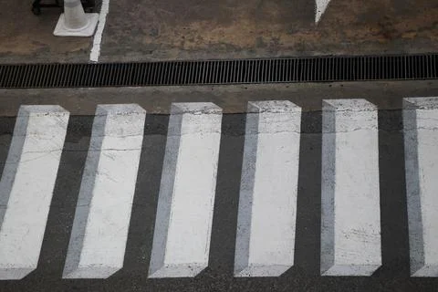 The crosswalk is designed to be three-dimensional white on concrete road Stock-Fotos