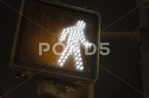 Crosswalk walk sign at night Stock Photos