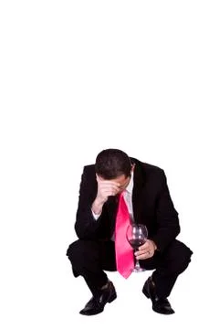 Crouched mediterranean man drinking Foto stock