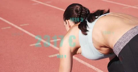 Crouching female runner preparing to sprint on red track with lanes, in Stock Photos