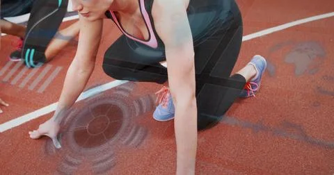 Crouching front sprinter placing hands on starting blocks and line at red tra Stock Photos