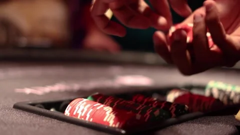 Croupier separating chips for distribution on a blackjack game table at casino Stock Footage 255680917