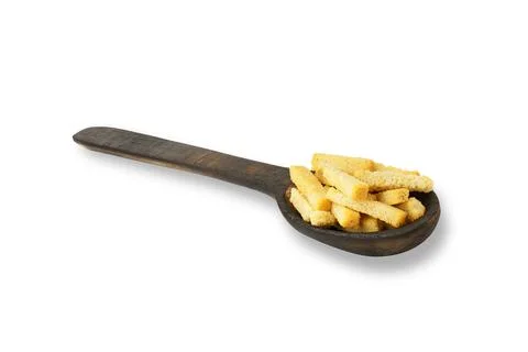 Croutons of white bread in a wooden spoon, isolated on white Stock Photos