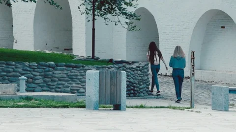 Crow digging in the trash in the Park. In the background are two young girls Stock Footage 108686049