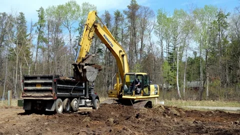 CROW WING CO, MN  10 MAY 2023: Excavator loads truck with brown soil Video stock 250629607
