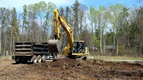 CROW WING CO, MN - 10 MAY 2023: Excavator scoops load of brown soil Video stock 250652732