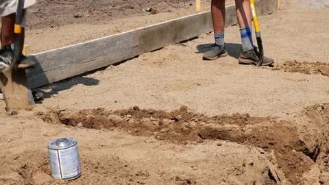 CROW WING CO, MN - 2 JUL 2021: Two men use shovels to dig a trench in the dirt. Stock Footage 158317442