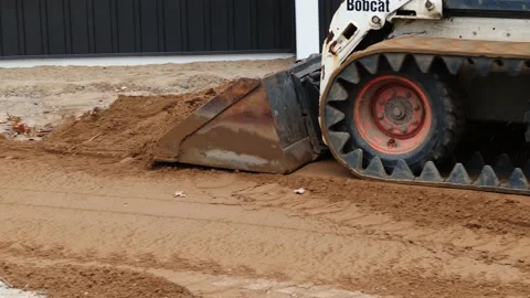 CROW WING CO, MN - 3 MAY 2021: A Bobcat compact front loader moves dirt Stock Footage 154869793