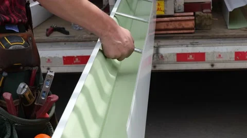 CROW WING CO, MN - 3 MAY 2021: Man installs aluminum rain gutter braces. Stock Footage 156759950
