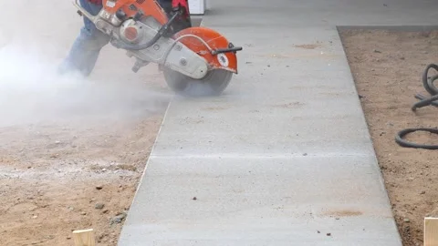 CROW WING CO, MN - 5 MAY 2021: A saw cut is made in new concrete sidewalk. Stock Footage 156813627