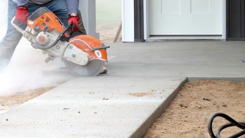 CROW WING CO, MN - 5 MAY 2021: Worker makes a saw cut in a new sidewalk. Stock Footage 156813925