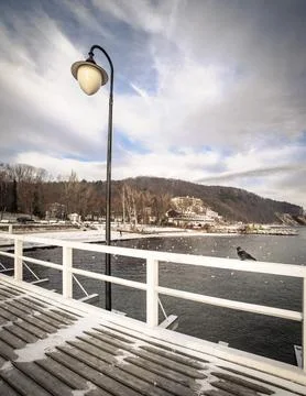 Crow on a Winter Pier with Lamp Post Stock Photos