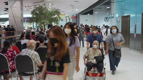 Crowd Of Asian People Sit &amp; Wait For Indoor Covid Flu Vaccination Clinic Видео 256096991