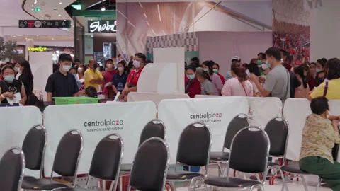 Crowd Of Asian People Stand &amp; Wait, Indoor Covid Flu Indoor Vaccination Clinic Stock Footage 256059725