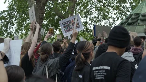 A crowd of Black lives Matter protesters waving anti racism banners in London Stock Footage 131995761