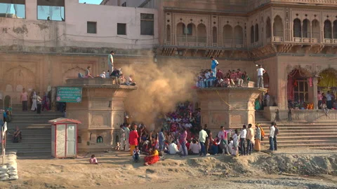 Crowd celebrating Holi with a cloud of yellow powder on historic stone ghats 库存影片 341109181
