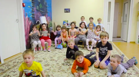 Crowd of Children Waving Their Hands to Greet the Camera in the Room in the Stockbeeldmateriaal 62187953