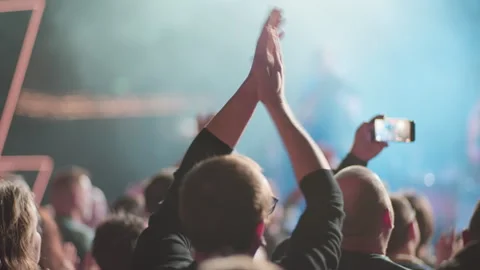 Crowd clapping with phone at concert in cyan stage atmosphere Stock Footage 334352120