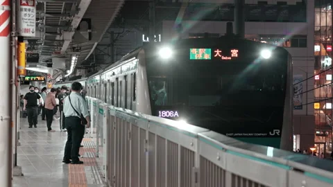 Crowd of commuters and passengers boarding commuter train on Keihin Tohoku Line  Stock Footage 219375260