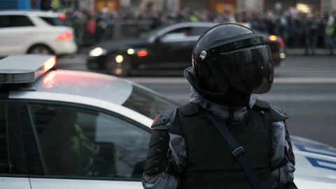 Crowd control unit operators in body armor enforcing law during daytime rally. Stock Footage 156747949