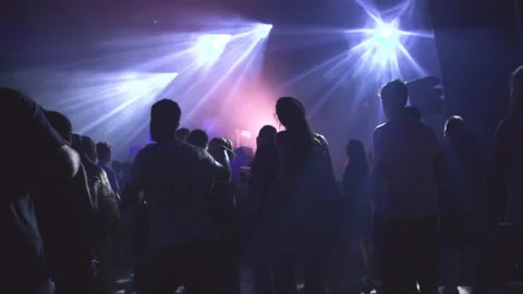 The crowd dances and has fun in a nightclub on techno music Stock Footage 237674809