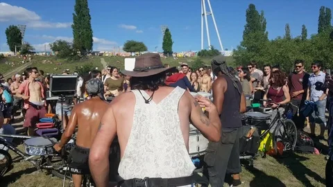 Crowd dances around drummers in Mauerpark, man in cowboy hat and overalls dances Видео 77410924