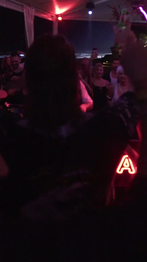Crowd Dancing Around DJ Booth at Beach Club Night Party 스톡 동영상 337902820