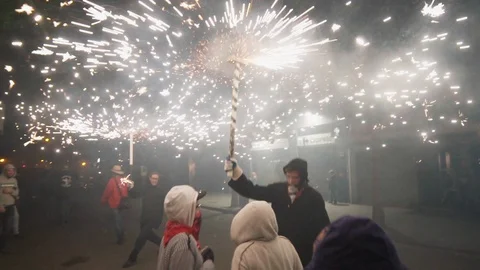 Crowd dancing with fireworks spinning above them  Stock Footage 100375494