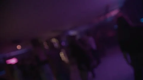 Crowd dancing under colorful spotlights and lasers, captured in defocused. Stock Footage 253594856