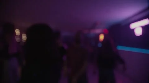 Crowd dancing under colorful spotlights and lasers, captured in defocused. Stock Footage 253594860