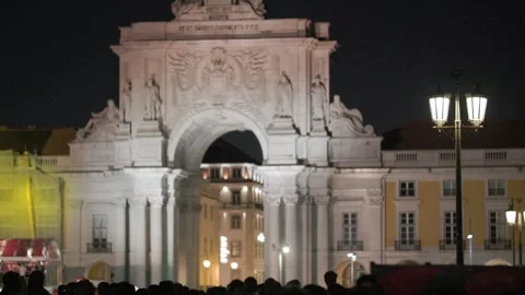 Crowd of diverse spectators gathered under illuminated archway at night Stock Footage 339002867