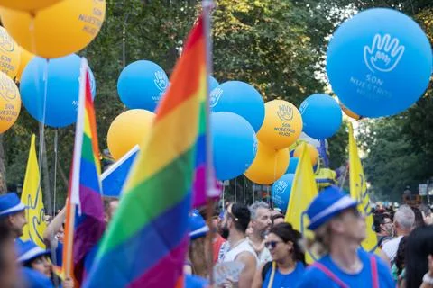 Crowd during the Madrid Pride Parade with yellow blue balloons and rainbow flags Foto stock