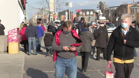Crowd of eople line up at pharmacy for COVID 19 vaccine shot in Toronto 库存影片 150340198