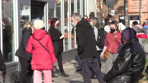 Crowd of eople line up at pharmacy for COVID 19 vaccine shot in Toronto Видео 150343286