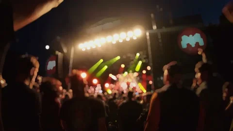 Crowd of fans are cheering at open-air music festival, back view. Live concert. 動画素材 154158492