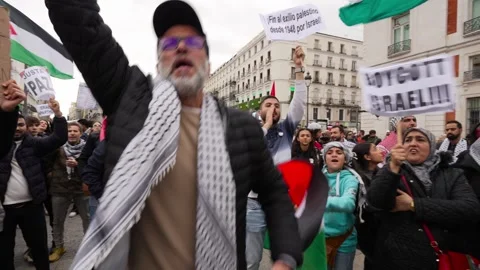 Crowd gathered shouting surrounded by flags during Pro-Palestine protest Stock Footage 254366417