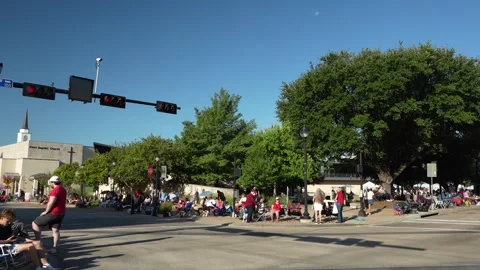 Crowd gathered at street intersection with traffic lights and church Stock Footage 340940757