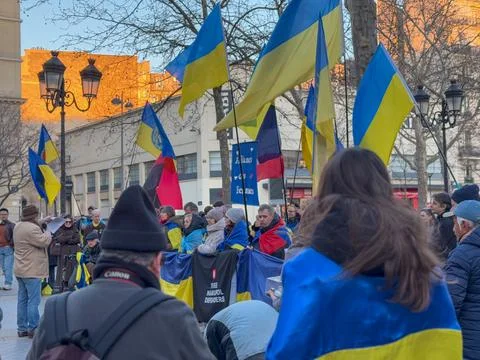 Crowd gathers with flags to rally for support in historic city square Stock Photos