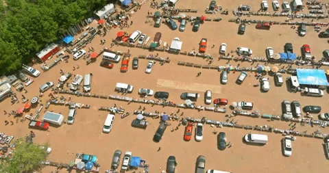 Crowd gathers in large parking area with cars stalls during weekend market event Stock Footage 337742661