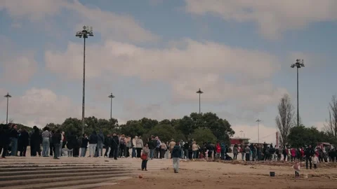 Crowd gathers near Belém Tower in Lisbon on cloudy day with scattered sunlight Stock Footage 312208181
