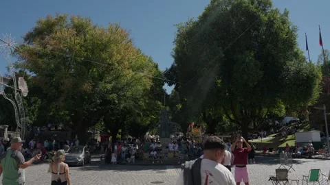 Crowd gathers in shaded town square during Feiras Novas Ponte de Lima Stock Footage 346133614