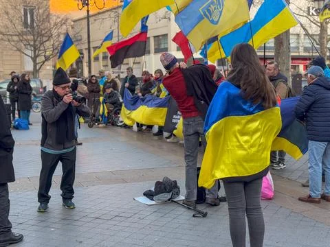 Crowd gathers to support Ukraine with flags in vibrant sunset atmosphere Stock Photos