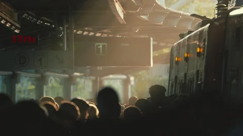 Crowd gathers at train station during evening rush hour while train arrives and Stock Footage 335627743