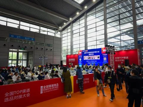 A crowd gathers to view the items on display with food industry infomation. Stock Photos
