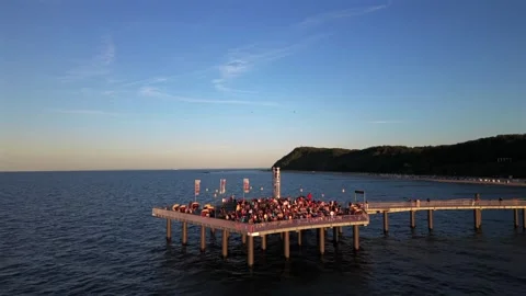 Crowd gathers on wooden pier platform to watch solar eclipse near Koserow Stock Footage 346191995