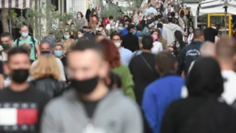 Crowd goes up and down a busy shopping street wearing a protective mask Stock Footage 142241473