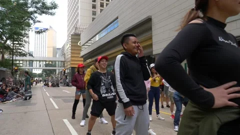 A crowd of happy people ready to do a flashmob on a busy street, zoom in Stock Footage 146590590