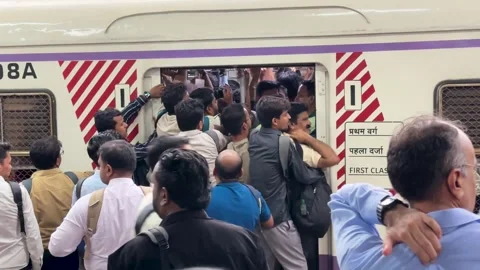 Crowd of Indian passengers hanging from an local train arriving at the station Stock Footage 341455715