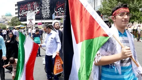 Crowd of Iranian demonstrators rally with flags against Israel during Quds day Stock Footage 70878894