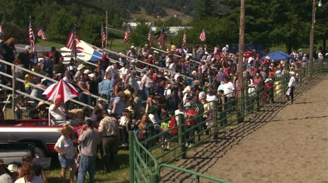 Crowd leaving the bleachers after a rodeo, clown talking to young fan Stock Footage 59533292